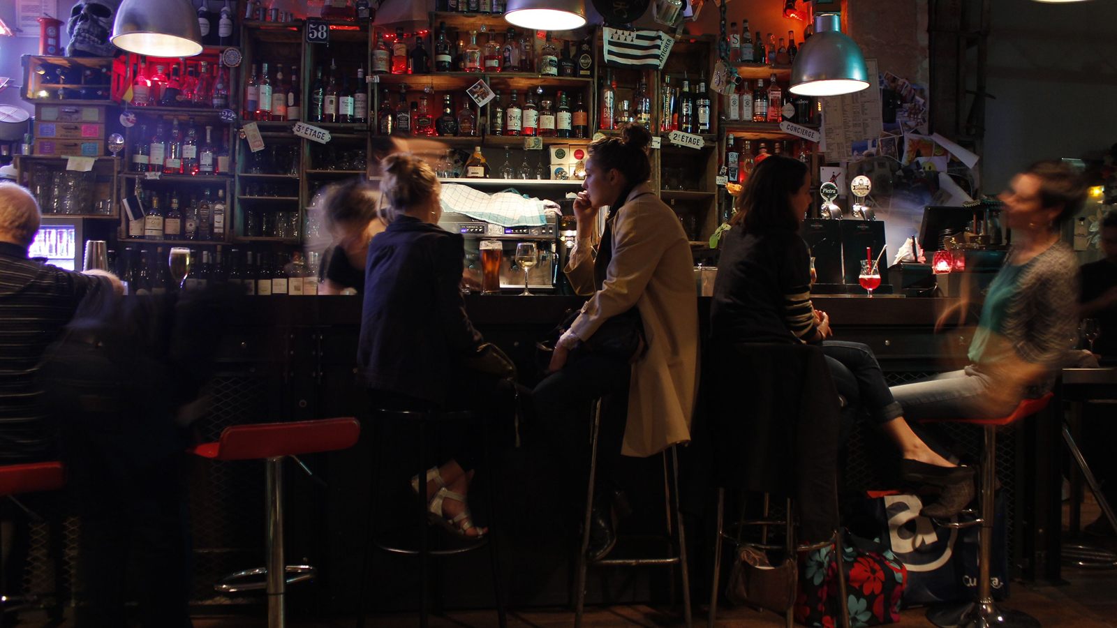 Soirée animée dans un bar, écran de jeu et clients qui participent sur leur smartphone