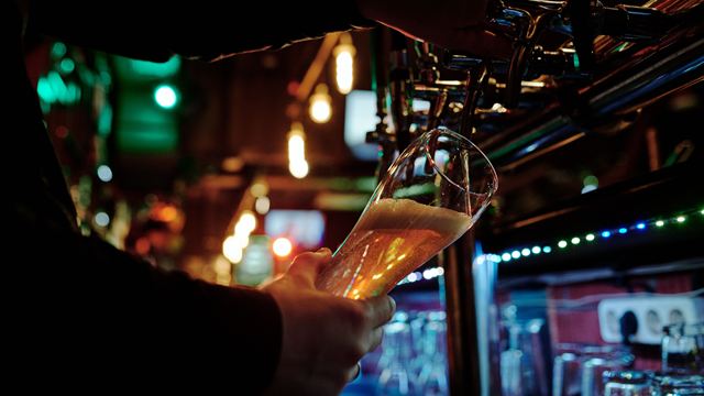 Bar animé un soir de semaine, clients en train de jouer sur leur téléphone
