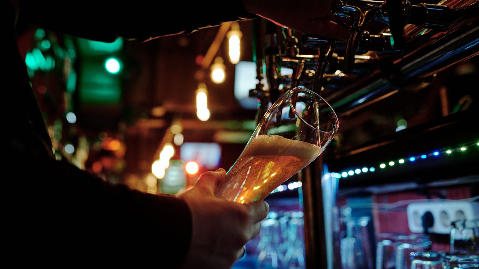 Bar animé un soir de semaine, clients en train de jouer sur leur téléphone
